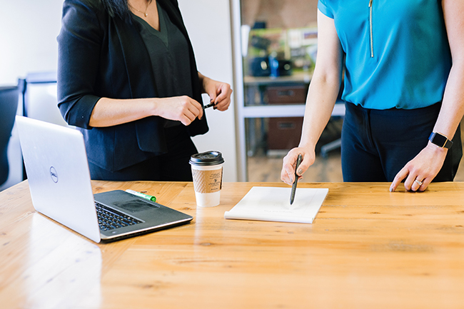 two people in office with laptop and documents